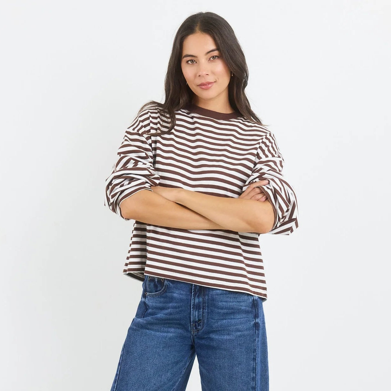 Woman wearing a striped shirt and blue jeans on a white background